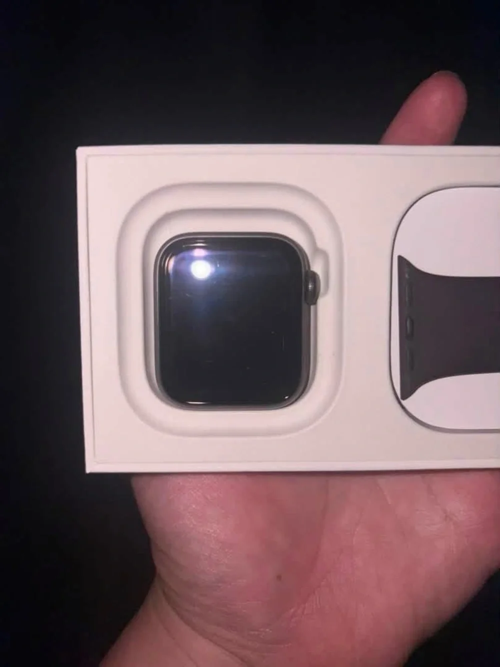 Apple SE GPS watch in grey aluminum case with maroon sports band.